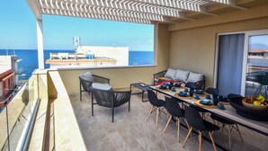 A balcony with a table set for dining, chairs, and a view of the sea. - 3 bedroom lovely apartment in Trappeto (Trappeto)