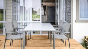 A modern outdoor dining area with a rectangular table and six chairs, set on a wooden deck. - Stunning home in Krynica Morska with WiFi (Krynica Morska)