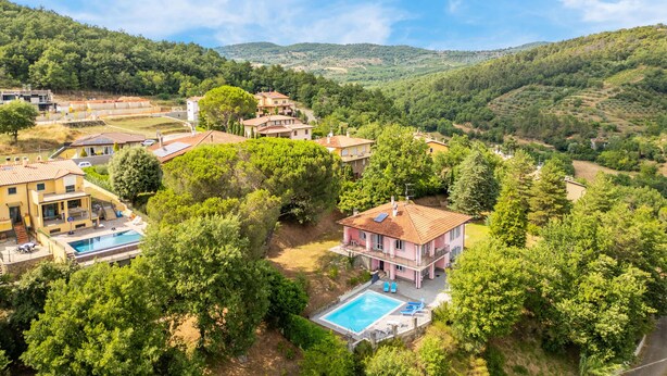 A residential area with houses, a swimming pool, and surrounding greenery. - Cozy home in Capolona (Capolona)
