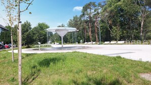 Un parque con una fuente central, bancos y árboles.