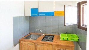 A small kitchen with a sink, stove, and wooden cabinets. - 2 bedroom lovely home in Zizanj (Zizanj)