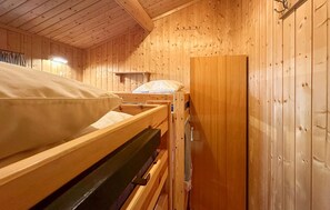 A wooden cabin room with a bunk bed, a small desk, and a wardrobe. - Beautiful home in Jordet with sauna (Jordet)