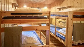 A cabin with bunk beds, wooden walls, and a sloped ceiling. - Beautiful home in Jordet with sauna (Jordet)