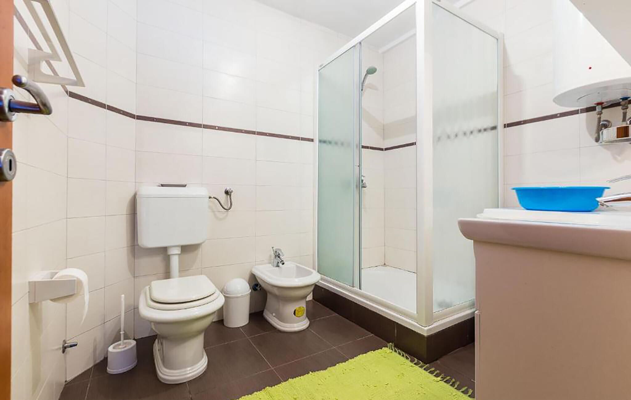 Une salle de bain équipée de toilettes, d’un bidet et d’une douche.