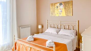 Une chambre à coucher avec un lit, un radiateur, un tableau et une fenêtre avec des rideaux.