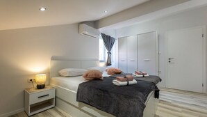 Un dormitorio moderno con cama, mesita de noche y armario.