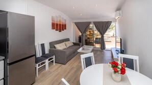 Un espacio de estar moderno con cocina, comedor y sofá.