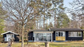 Ein zweistöckiges Haus mit großer Glasfront und einer kleinen angeschlossenen Garage.