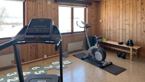 Una palestra con tapis roulant, cyclette e pesi.