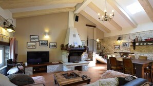 A cozy living room with a fireplace, a TV, and comfortable seating. - Beautiful home in Porec (Porec)