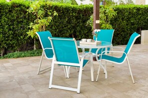 A round table with four chairs, a vase with flowers, and a tray with cups and saucers. - Xuru Stays I Sundown Symphony 4mbdr Villa @ Joubal El Gouna (El Gouna)