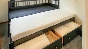Un lit superposé avec un matelas et deux tiroirs en dessous.