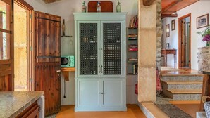 A rustic interior with a light blue cabinet, wooden doors, and a stone staircase.