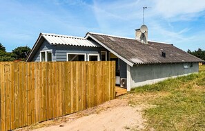 A house with a sloped roof, a satellite dish, and a wooden fence. - Beautiful home in Thisted with sauna (Thisted)