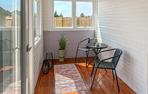 A small patio area with a table and chairs, a potted plant, and a colorful rug. - Beautiful home in Thisted with sauna (Thisted)