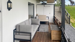 Un espacio de estar al aire libre cubierto con un sofá, una silla y una mesita.
