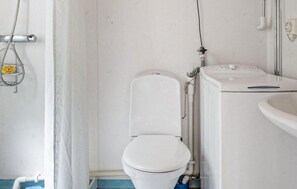 Une salle de bain comprenant des toilettes, un lavabo et un espace douche.