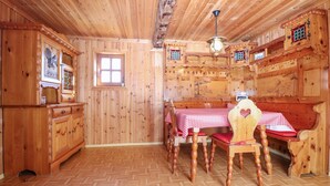 A wooden interior with a checkered table, wooden chairs, a cabinet, and a window. - Beautiful home in Stadl an der Mur (Stadl an der Mur)