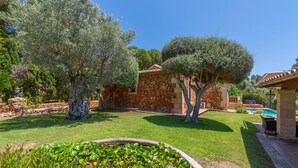 A well-maintained garden with a swimming pool, stone walls, and a variety of trees. - Amazing home in Son Servera (Son Servera)