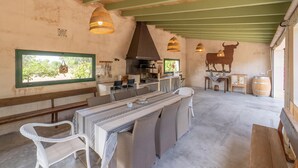 Eine rustikale Küche mit einem großen Herd, hängenden Lampen und einem Bullen-Wandbild.