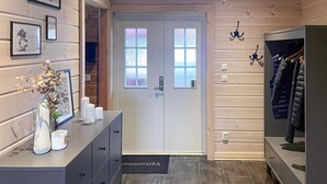 A wooden interior with a door, a coat rack, and a dresser with decorative items. - Beautiful home in Charlottenberg (Charlottenberg)