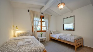 A bedroom with two beds, a nightstand, a window with curtains, and a hanging light fixture. - 1 bedroom lovely home in Andrasevec (Andrasevec)
