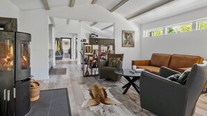 Una sala de estar moderna con chimenea, sofá de cuero y estantería.
