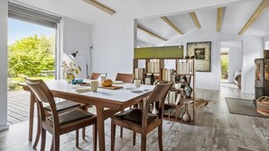 Un comedor espacioso con una mesa y sillas de madera, una estantería y una chimenea.