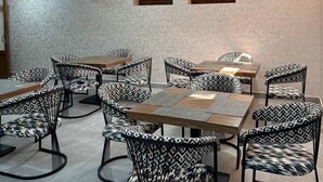 Una sala de conferencias con una larga mesa y múltiples sillas, con un diseño moderno que presenta patrones geométricos en los tapizados.