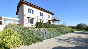 A two-story house with a sloped roof, a covered patio, and a gravel driveway. - Nice apartment in Terranuova Bracciolini (Terranuova Bracciolini)