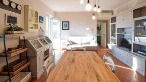 A cozy kitchen with a wooden table, white cabinets, and a dining area with chairs. - Nice apartment in Terranuova Bracciolini (Terranuova Bracciolini)