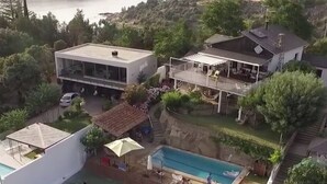 En bostadsfastighet med en swimmingpool, en täckt uteplats och ett stort hus med en balkong.