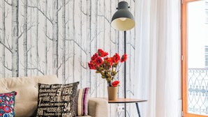 A living room with a sofa, a coffee table, a floor lamp, and a window with curtains. - Chiado Mercy I (Lisbon)
