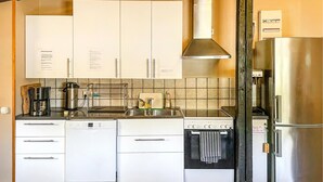A kitchen with white cabinets, a Bosch oven, a Bosch dishwasher, a coffee maker, and a stainless steel refrigerator. - Nice apartment in Höör (Höör)