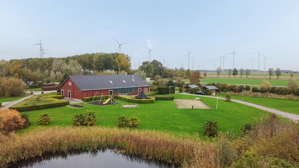 A rural setting with a red barn, a playground, and a pond. - Amazing home in Wagenborgen with WiFi (Wagenborgen)
