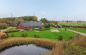 A rural setting with a red barn, a playground, and a pond. - Amazing home in Wagenborgen with WiFi (Wagenborgen)