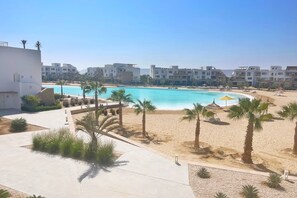Un resort con piscina, playa y varias edificaciones.