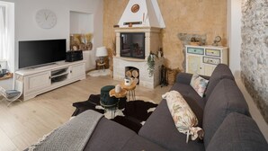 Un salon avec une cheminée, un téléviseur et un canapé.