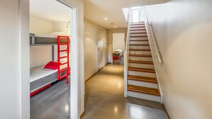 A narrow hallway with a bunk bed on the left and a wooden staircase on the right. - Amazing apartment in Søgne with WiFi (Søgne)