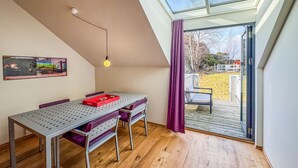A dining area with a table and chairs, a pendant light, and a view through a glass door to an outdoor deck. - Amazing apartment in Søgne with WiFi (Søgne)