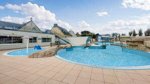 A swimming pool with a dolphin statue, a slide, and a building with a glass roof. - 2 bedroom beautiful home in Ambon (Ambon)