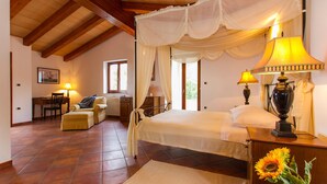 A bedroom with a canopy bed, a desk, and a chair.