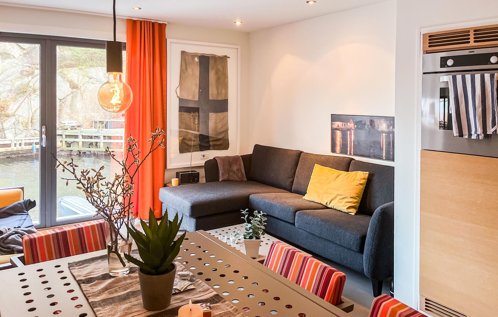 Una sala de estar moderna con un sofá, una mesa de comedor y una planta en maceta.