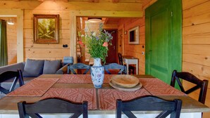 A wooden interior with a dining table set for four, a vase with flowers, and a painting on the wall. - Cozy home in Czaplinek with lake view (Czaplinek)