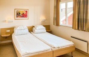 A twin room with two beds, a painting on the wall, and a window with curtains. - Beautiful home in Hok with WiFi (Hok)
