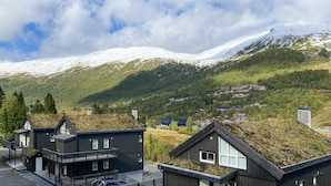 A modern building with a flat roof and large windows, surrounded by a snowy mountain landscape.