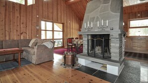 A cozy cabin interior with a stone fireplace, wooden walls, and a comfortable seating area. - Beautiful home in Koppom with sauna (Koppom)