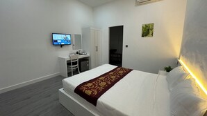 A modern hotel room with a bed, desk, and TV. - Aure Residence Hotel (Sihanoukville)