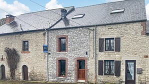 A stone building with a tiled roof, multiple windows, and a visible door. - 2 bedroom pet friendly home in Treignes (Treignes)