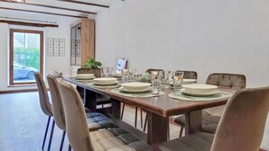A dining area with a long table set for four, surrounded by cushioned chairs. - 2 bedroom pet friendly home in Treignes (Treignes)